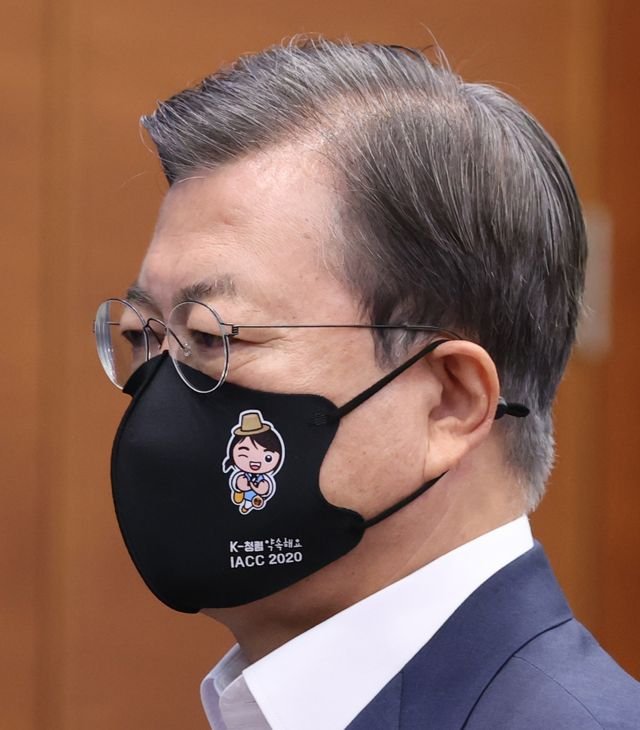 Moon Jae-in wears a cartoon mask for a meeting written "CLEAN" on it