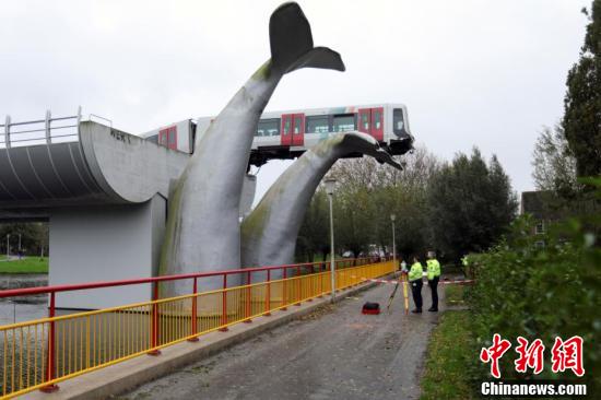 Dutch light rail rushes out of the track and is caught by a whale tail sculpture