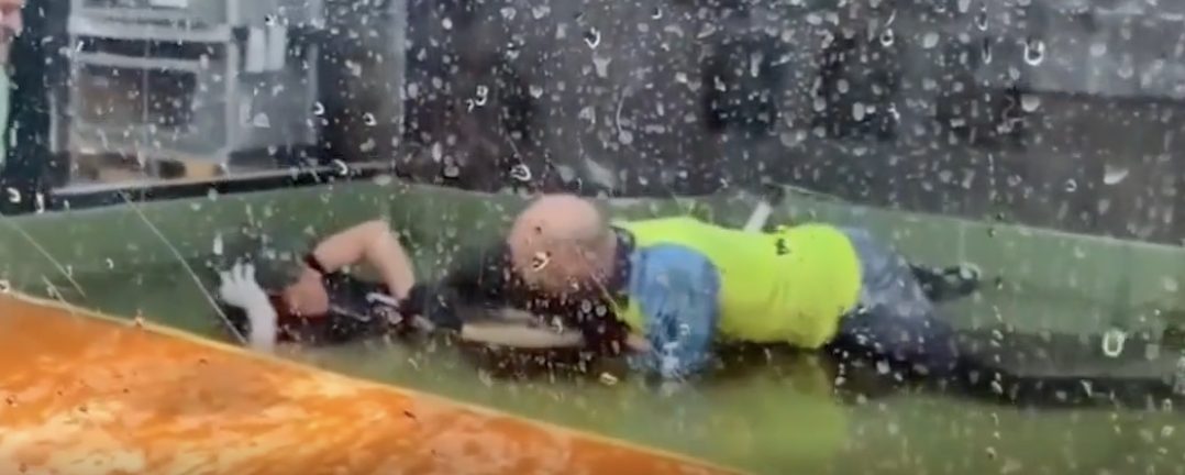 A crocodile bites a keeper at a U.S. zoo. Tourists jump into a fence to rescue them